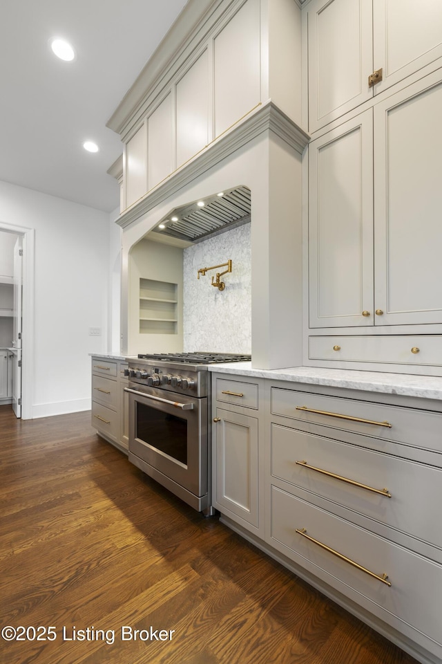 kitchen featuring dark hardwood / wood-style flooring, backsplash, and stainless steel stove