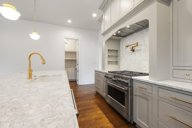 kitchen with backsplash, stainless steel stove, gray cabinetry, and sink