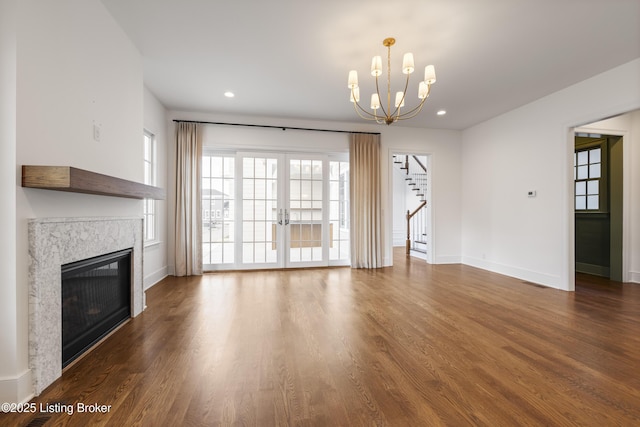 unfurnished living room featuring dark wood-type flooring and a notable chandelier