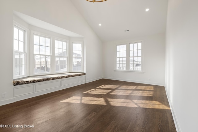 spare room featuring high vaulted ceiling and dark wood-type flooring