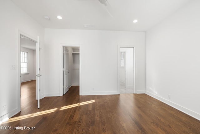 unfurnished bedroom with dark hardwood / wood-style floors, a spacious closet, and a closet