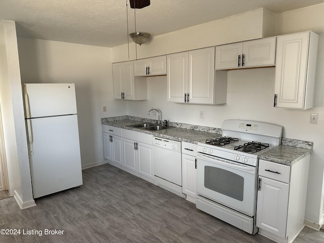 kitchen with a textured ceiling, white appliances, sink, hardwood / wood-style flooring, and white cabinets