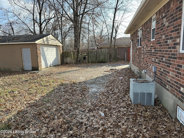 view of yard featuring central AC, a garage, and an outdoor structure