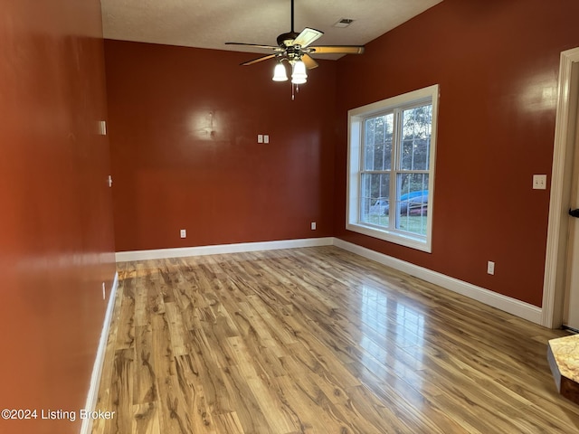 empty room featuring ceiling fan, a textured ceiling, and light wood-type flooring