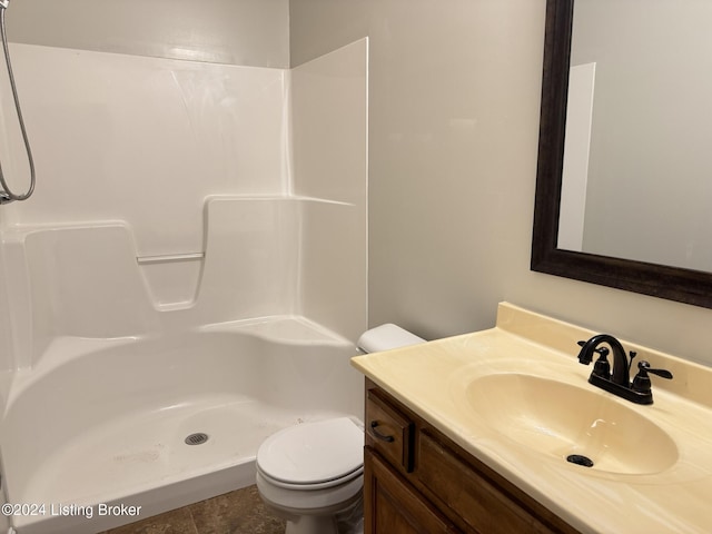 bathroom featuring a shower, vanity, toilet, and tile patterned flooring