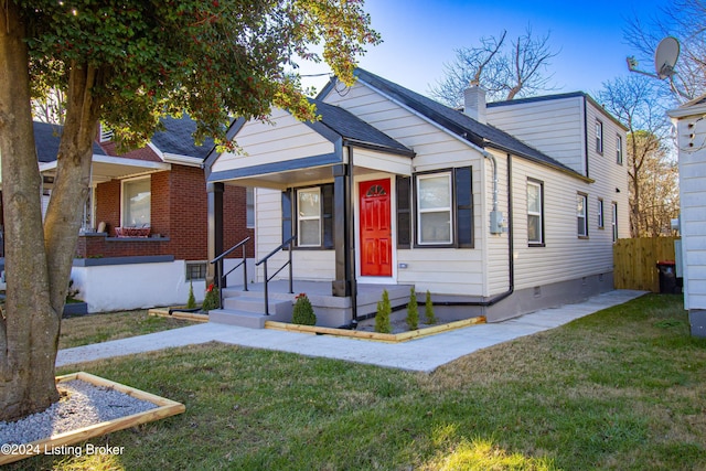 bungalow-style home featuring a front lawn