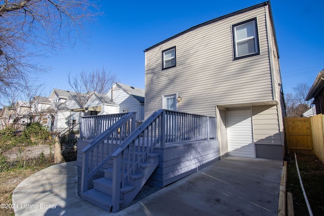 back of property with a deck and a patio