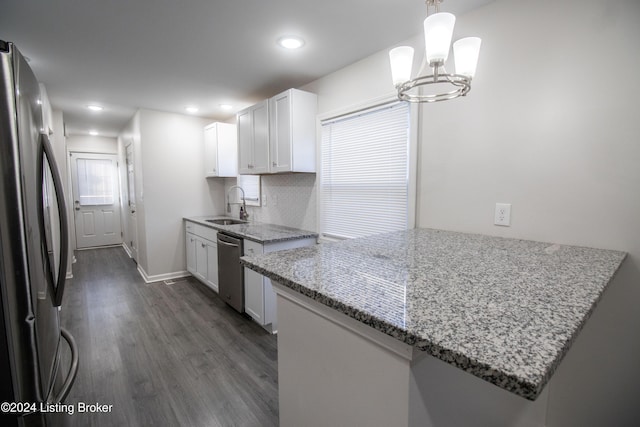 kitchen with kitchen peninsula, appliances with stainless steel finishes, white cabinets, and sink