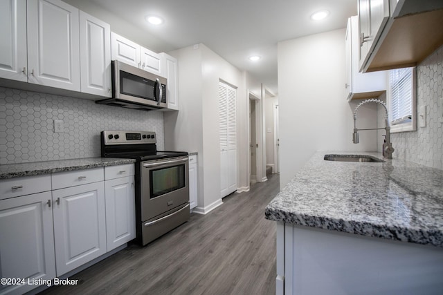 kitchen with sink, stainless steel appliances, dark hardwood / wood-style flooring, decorative backsplash, and white cabinets