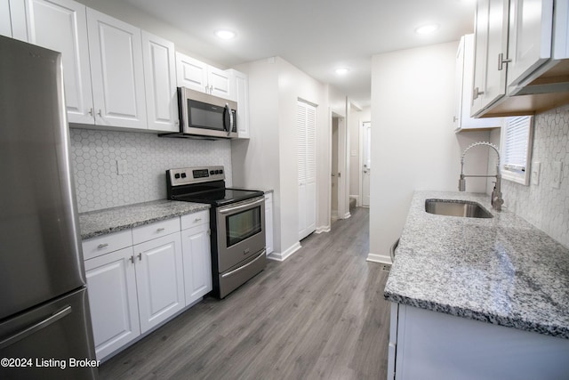 kitchen featuring white cabinets, stainless steel appliances, light hardwood / wood-style flooring, and sink