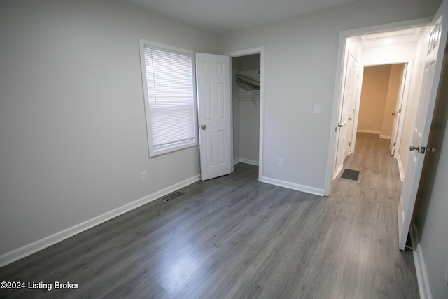 unfurnished bedroom with a closet and hardwood / wood-style flooring