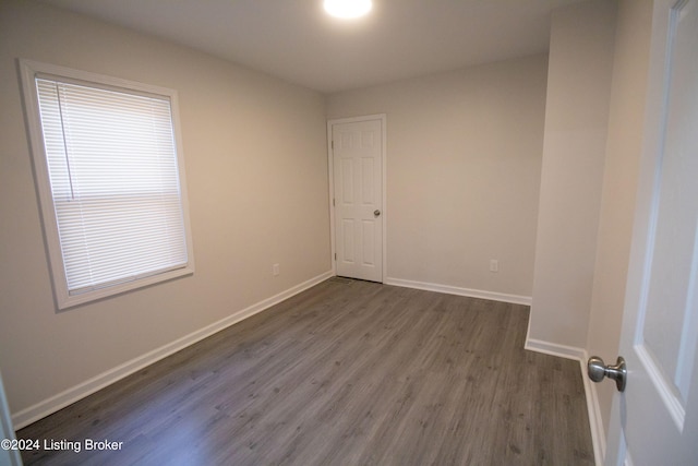 empty room with plenty of natural light and dark wood-type flooring