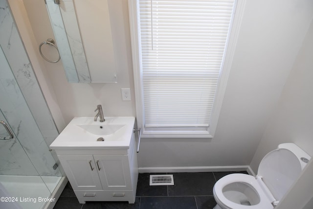 bathroom with toilet, vanity, and tile patterned floors