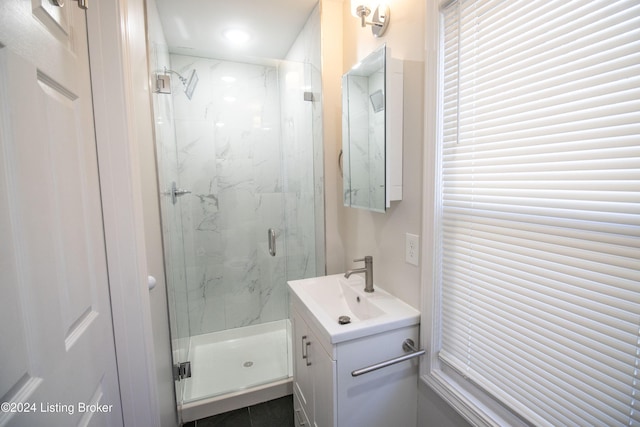 bathroom with a shower with door and vanity