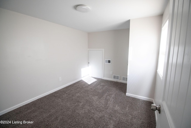 unfurnished room with dark carpet