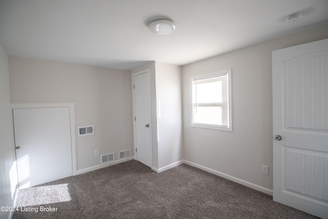 empty room featuring dark colored carpet