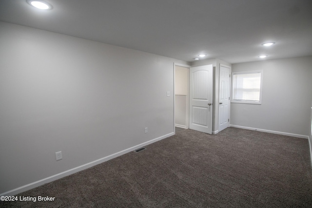 basement featuring dark colored carpet