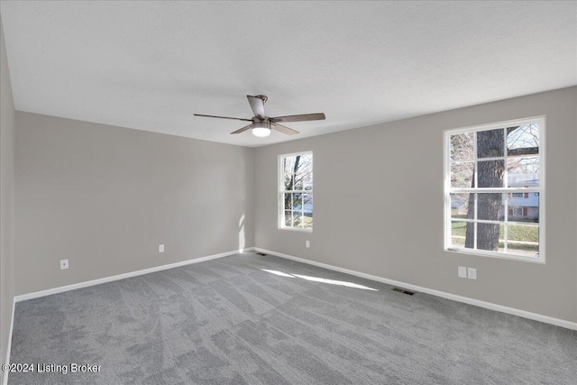 empty room featuring carpet floors and ceiling fan