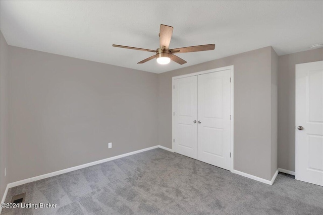 unfurnished bedroom with a closet, ceiling fan, and light colored carpet