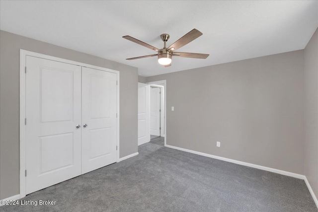 unfurnished bedroom with ceiling fan, a closet, and dark colored carpet