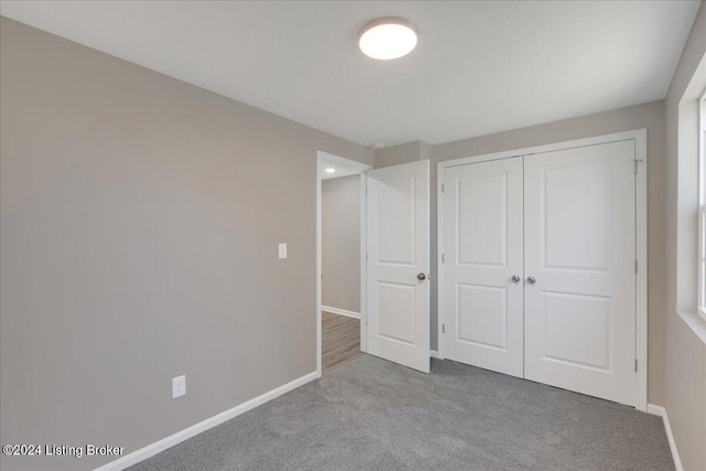 unfurnished bedroom featuring light colored carpet and a closet