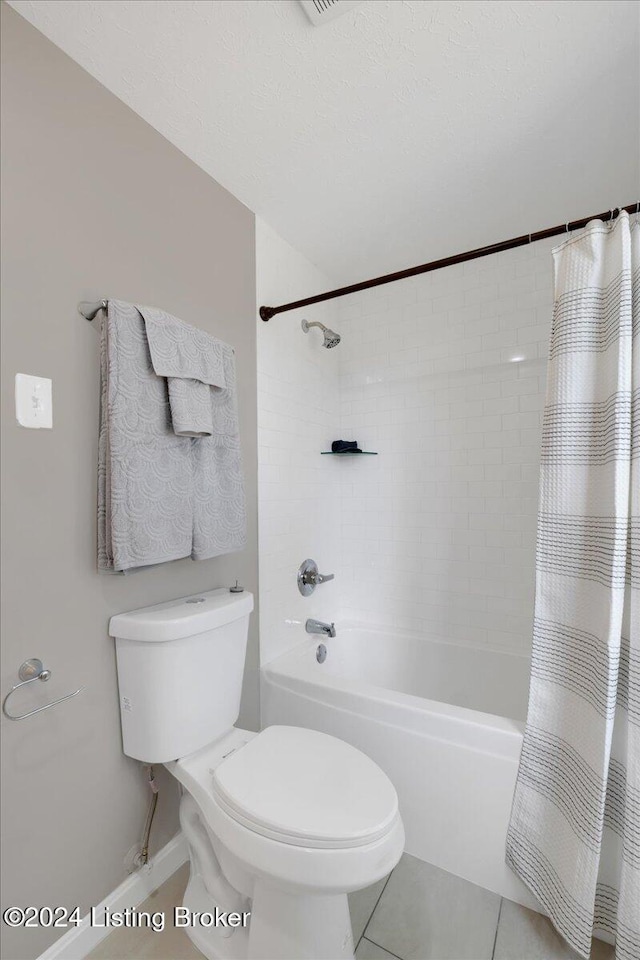 bathroom featuring tile patterned flooring, shower / tub combo, and toilet