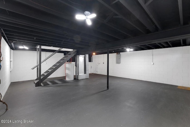 basement featuring electric water heater, electric panel, and heating unit