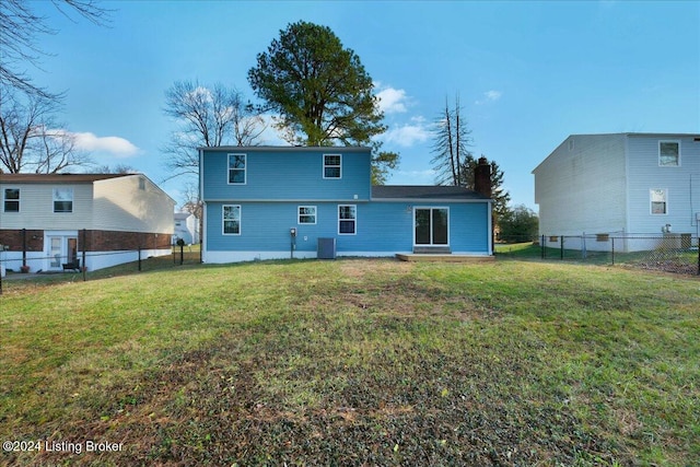 back of house featuring a lawn and central air condition unit