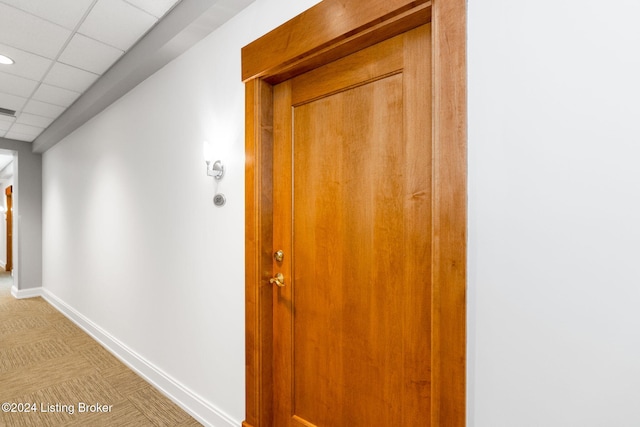 hall with a paneled ceiling