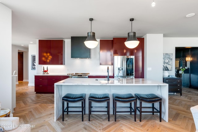 kitchen with decorative light fixtures, sink, stainless steel refrigerator with ice dispenser, and light parquet flooring