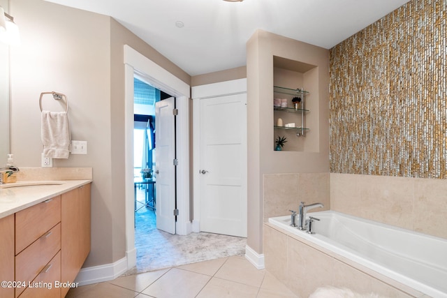 bathroom featuring tile patterned flooring, vanity, and a relaxing tiled tub