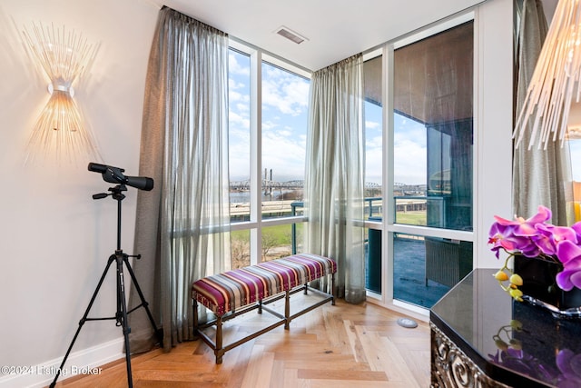 living area with light parquet flooring and a wall of windows