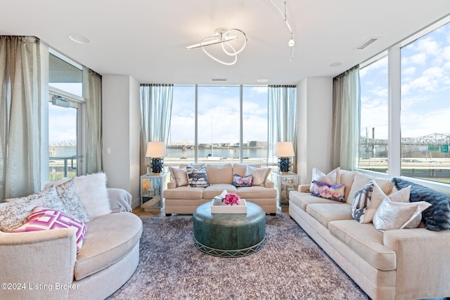 living room featuring expansive windows, a wealth of natural light, and a water view