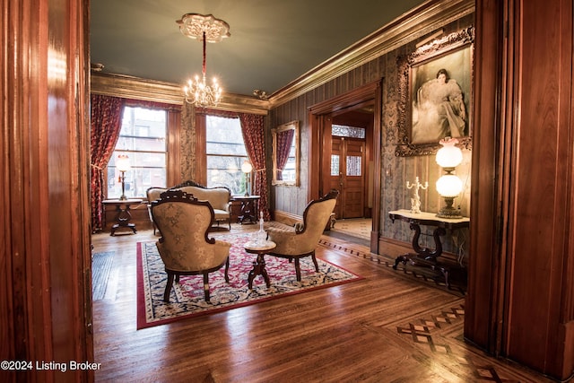 living area featuring a chandelier, ornamental molding, and hardwood / wood-style flooring