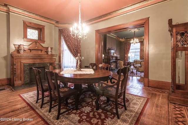 dining space with crown molding, hardwood / wood-style floors, and an inviting chandelier