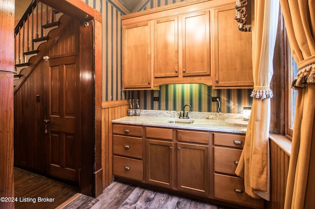 kitchen with light stone counters, sink, and dark wood-type flooring