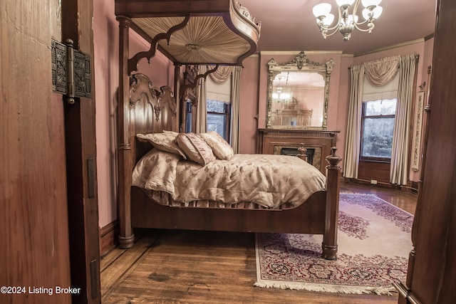 bedroom featuring crown molding, dark wood-type flooring, and a notable chandelier