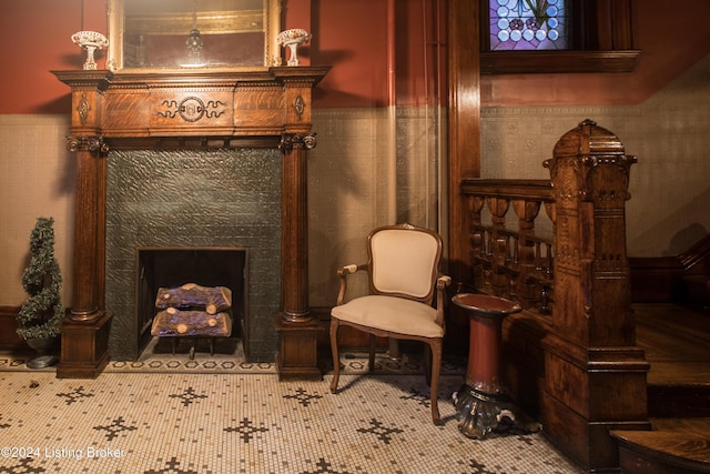 sitting room with tile patterned floors, a fireplace, and tile walls