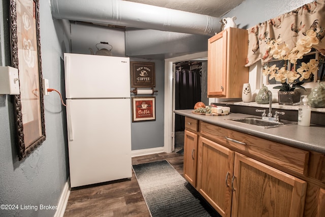 kitchen featuring white fridge, dark hardwood / wood-style floors, and sink