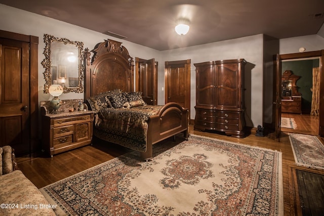 bedroom with dark wood-type flooring