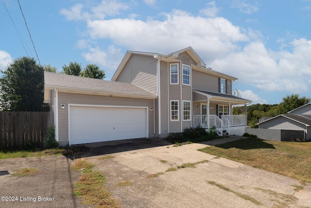 view of front of home featuring a front yard, a porch, and a garage