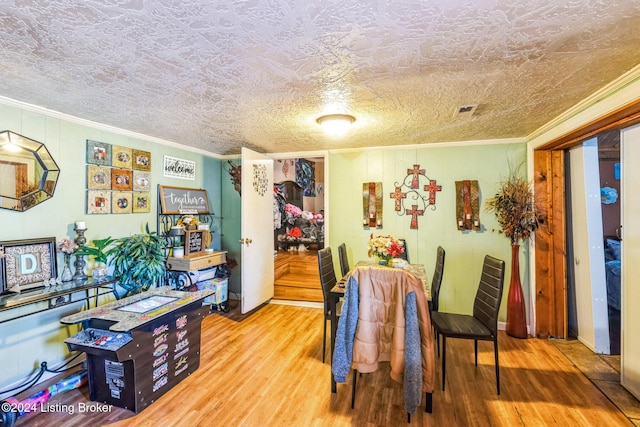 dining room with hardwood / wood-style floors and ornamental molding