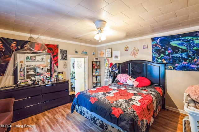 bedroom with crown molding, ceiling fan, and wood-type flooring