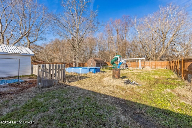 view of yard featuring a fenced in pool and a playground