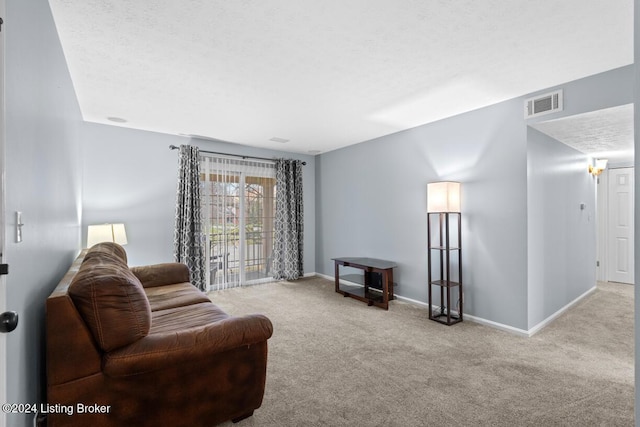 living room featuring light carpet and a textured ceiling