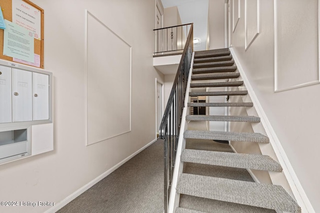 stairway featuring carpet and a high ceiling