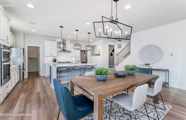 dining room with light hardwood / wood-style floors, sink, and a chandelier