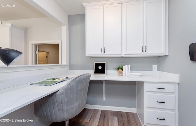 office space with built in desk and light hardwood / wood-style flooring