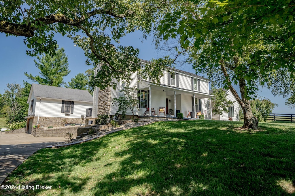 view of front property with covered porch and a front yard