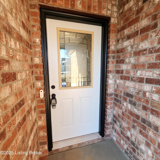 entrance to property featuring brick siding